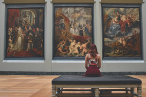 Traveller looking at paintings of art exhibition