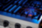 Close-up of a stove top with blue gas flame