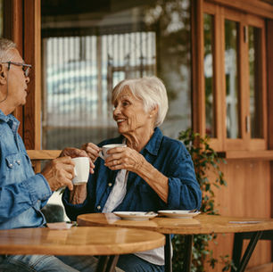 Older couple having coffee together in a café and talking calmly