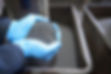 Worker with handful of steel shot in steel foundry