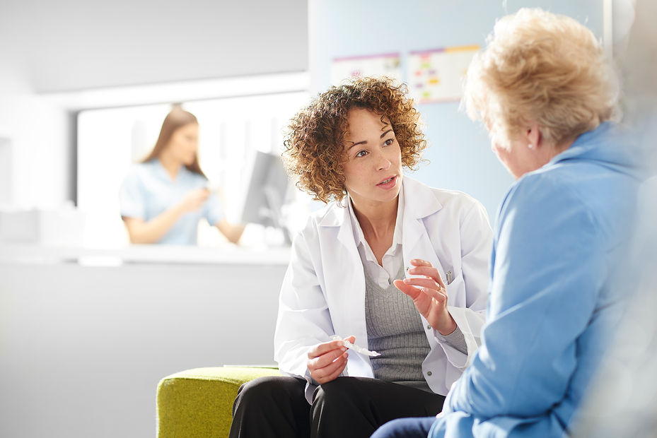 A female pharmacist sits with a senior female patient in the pharmacist consultation area