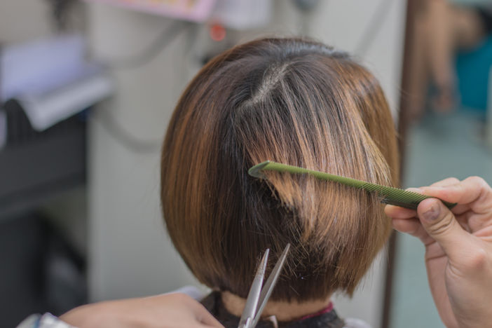 Frau lässt sich die Haare schneiden