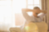 Rear view of man relaxing on chair at home
