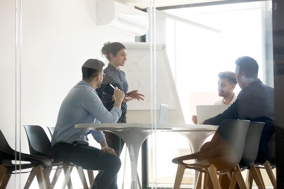 Diverse Gruppe diskutiert KI-Strategie an Glaswand mit Notizen