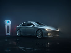 Silver car charging at a station in a dimly lit setting. Blue glow from the station and car highlights on wet pavement create a sleek, futuristic mood.