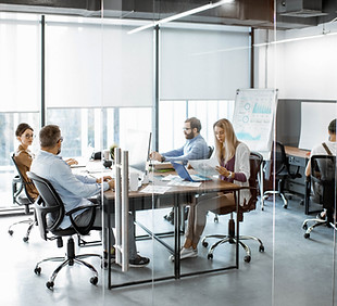 Equipe trabalhando em escritório particionado de vidro