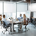 Equipo de trabajo en oficina con mampara de vidrio