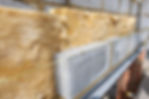 A brick wall partially covered with insulation material, showcasing the construction process and thermal protection