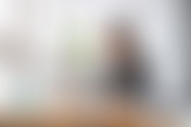 Eine Frau sitzt an ihrem Laptop. Lächelt und hat vielleicht ihre erste neue Firma gegründet.