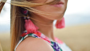 face of a woman with pink earrings