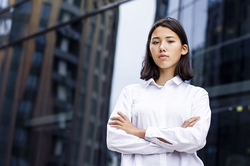Serious Asian young woman standing outdoor