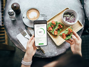 Phone displaying calorie tracking app next to a healthy meal
