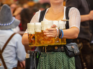 Kellnerien serviert viele Maßkrüge Bier im Wiesnzelt