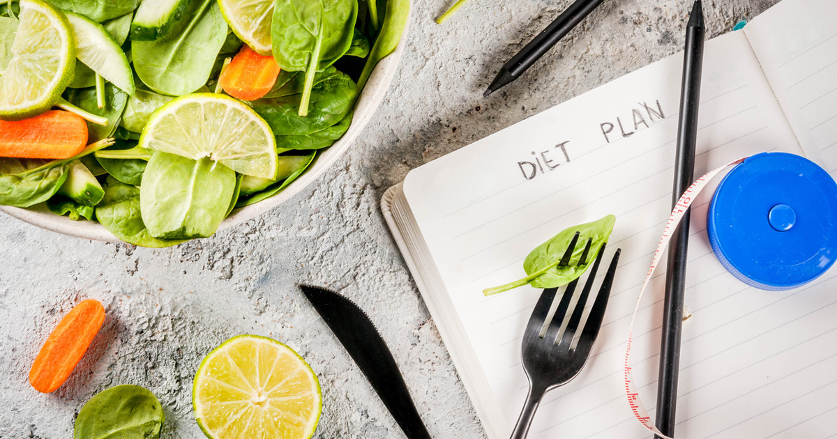 A person reviewing a personalised nutrition plan while setting realistic health goals and preparing healthy meals.