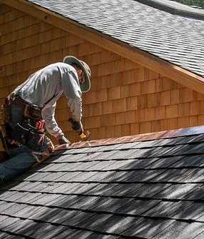 A Roofer Fixing Shingles Roof