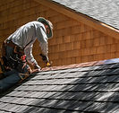 A Roofer Fixing Shingles Roof