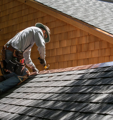 A Roofer Fixing Shingles Roof