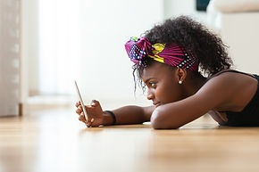 black girl lying on floor looking at phone