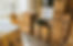 A sunny living room with many cardboard boxes, filled with possessions, alluding to moving