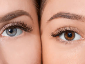Close-up of two eyes with long lashes; one blue, one brown. Neutral background, focus on eye colour and detail. Mood: contemplative.