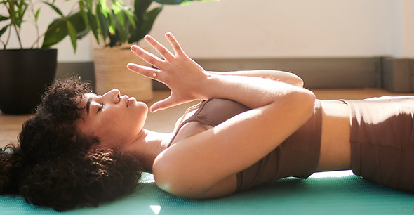 A yoga student lying down on her yoga mat