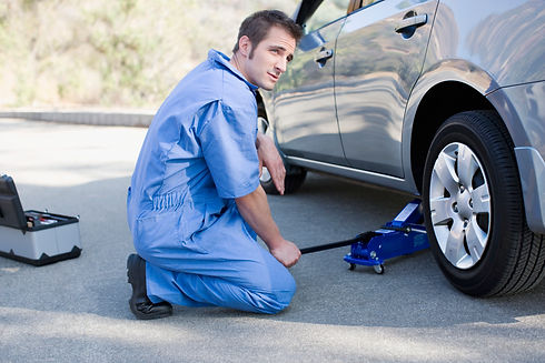 Mechanic changing cars flat tire
