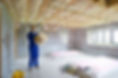 Man holding ceiling insulation in house under construction