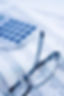 Desktop calculator and glasses resting on financial paper documents