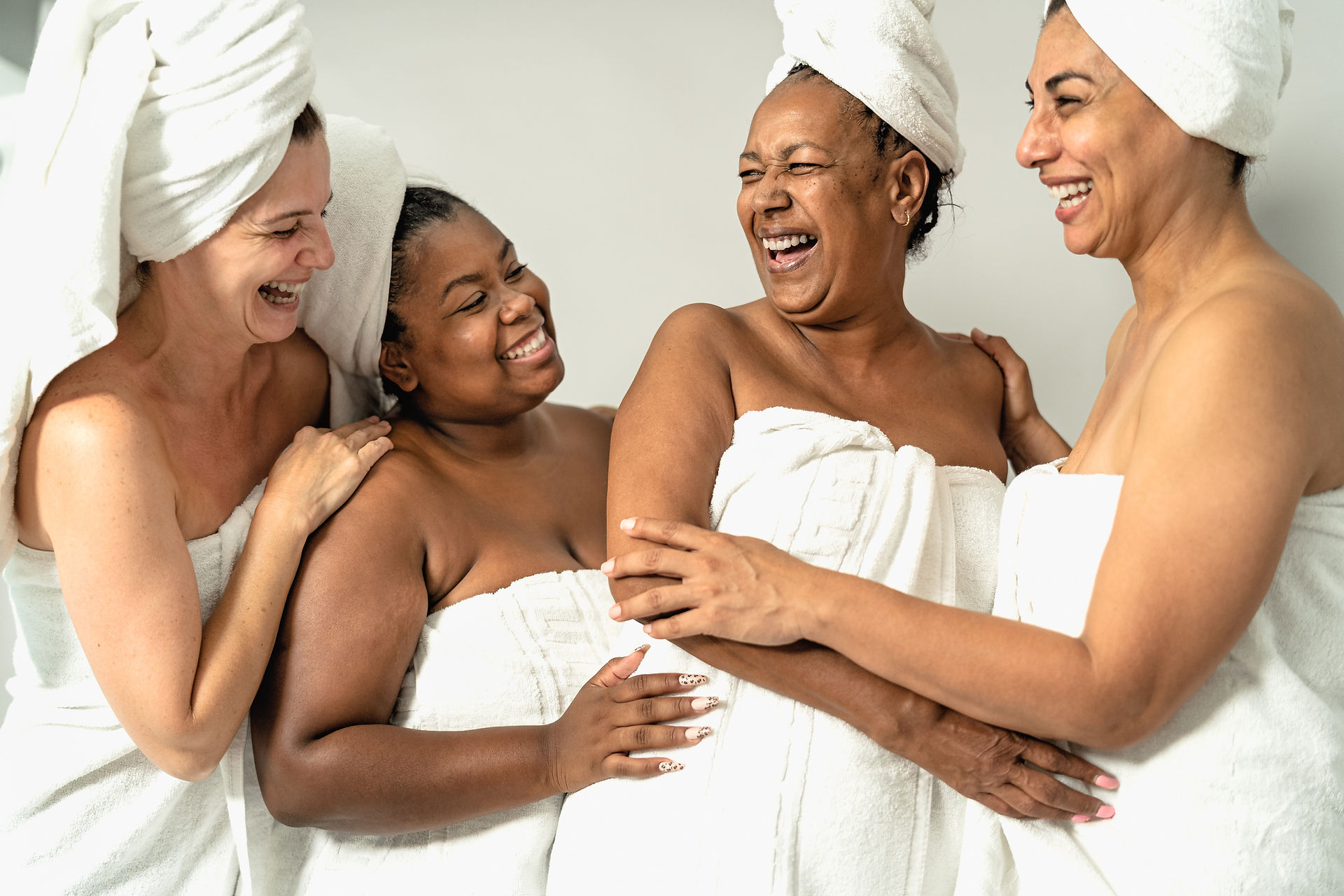 4 happy ladies wearing towels and head wrapped