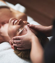 As mãos de um Terapeuta, massoterapeuta, fazendo massagem na cabeça de uma mulher. Especificamente na testa, dessa forma vai promover relaxamento.