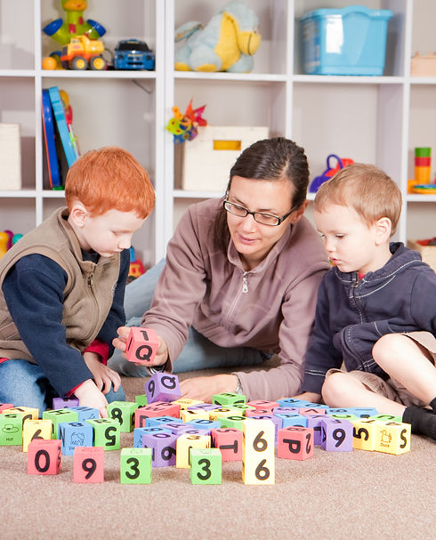 Mother playing blocks games with boys