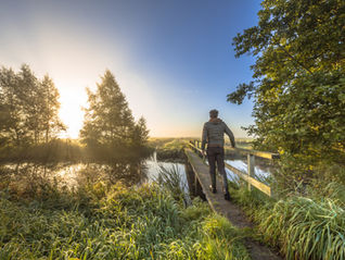 A person walking over a bridge outdoors.