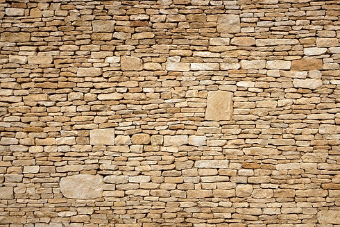 Detailed texture of a traditional random stone wall with lime pointing