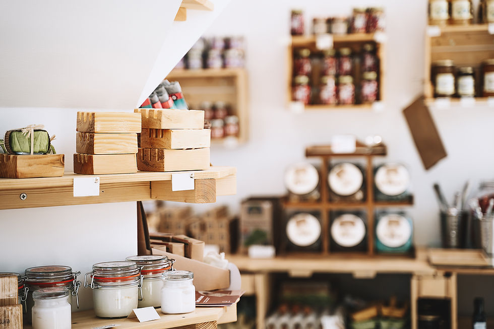 A local shop display featuring handmade goods, including snacks, crafts, and wellness products, which were included in a corporate welcome gift for conference attendees. The items are neatly arranged on shelves, with the shop's cozy, inviting atmosphere and branding visible in the background.