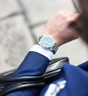 Mann schaut auf seine Uhr