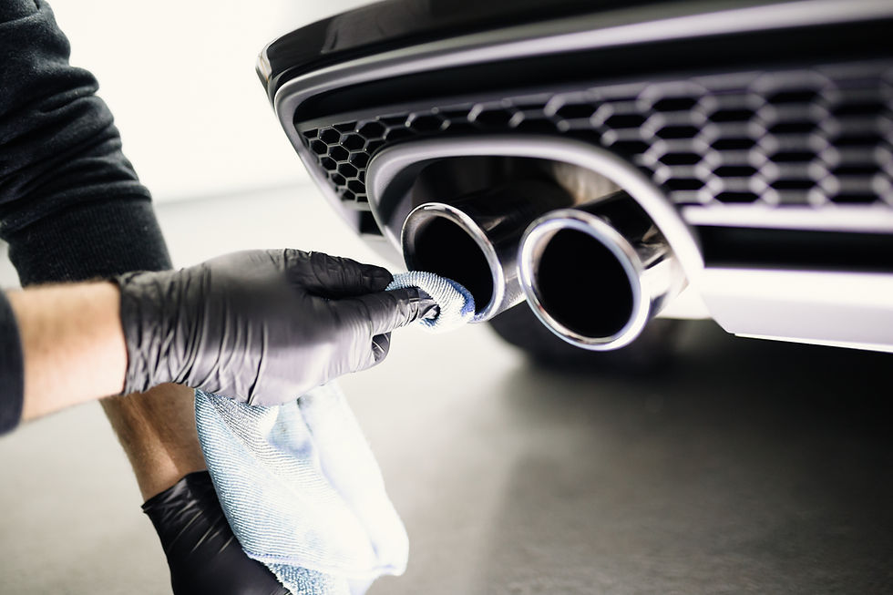 close-up image of a person's hand while cleaning car exhaust