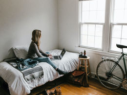 Woman sitting quietly on her bed after taking time for herself