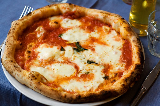 Pizza Margherita topped with tomato, and sliced mozzarella