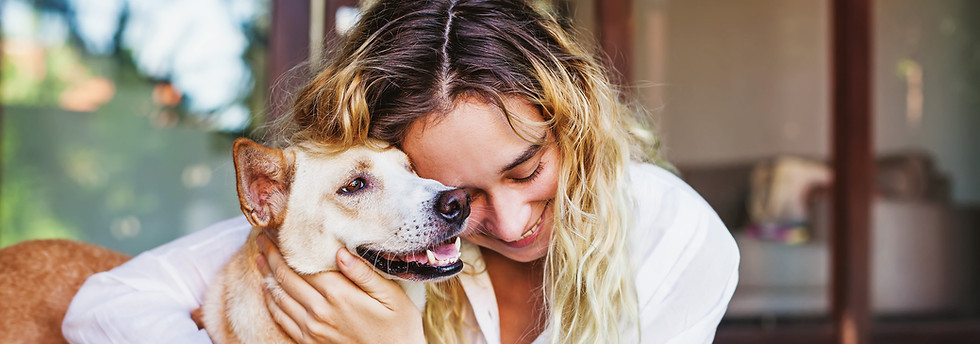 woman smiling and hugging a happy dog