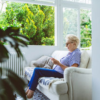Elder woman sitting by an open window
