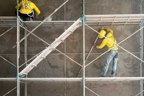 Construction worker plastering cement on concrete block wall