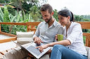 A white couple watching an online class on a laptop computer screen