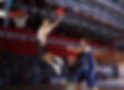 Basketballer in white jersey attempting a slam dunk