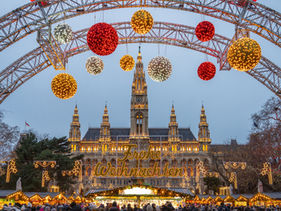 Wiener Rathaus mit Weihnachtsbeleuchtung beim Christkindlmarkt am Rathausplatz im Winter