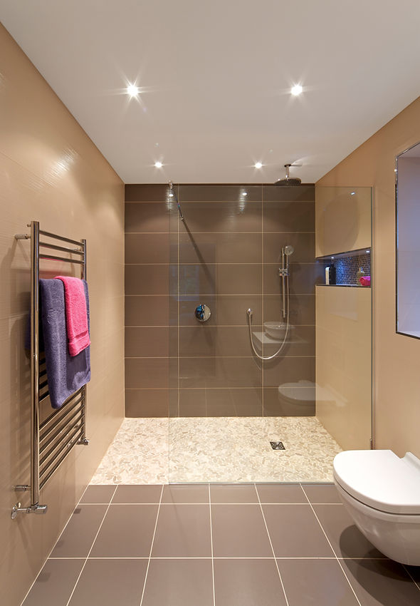 "a modern shower unit in a guest's bathroom of a luxury new home. The walls are lined with