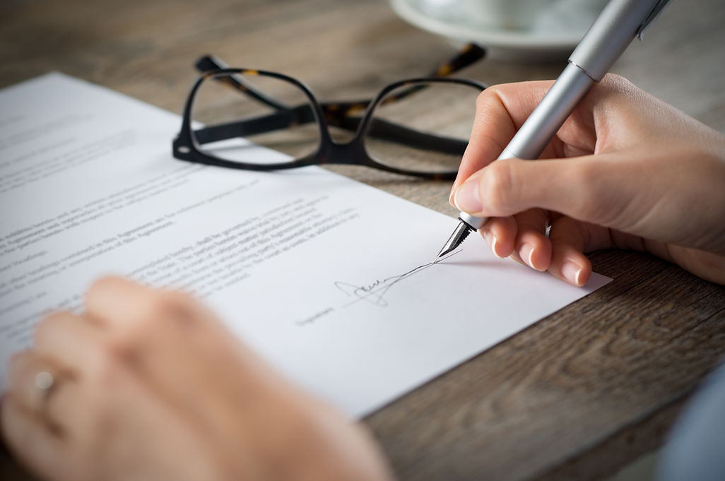 Close-up shot of a woman signing a form
