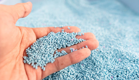 Under the bottle image and to the bottom right of the black and white editorial image, is a hand holding small pieces of light blue plastic, to show how big plastic becomes smaller plastic and it ties into the polyester blog.