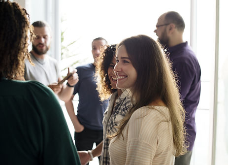 A group of adults talking and smiling to each other in a professional gathering