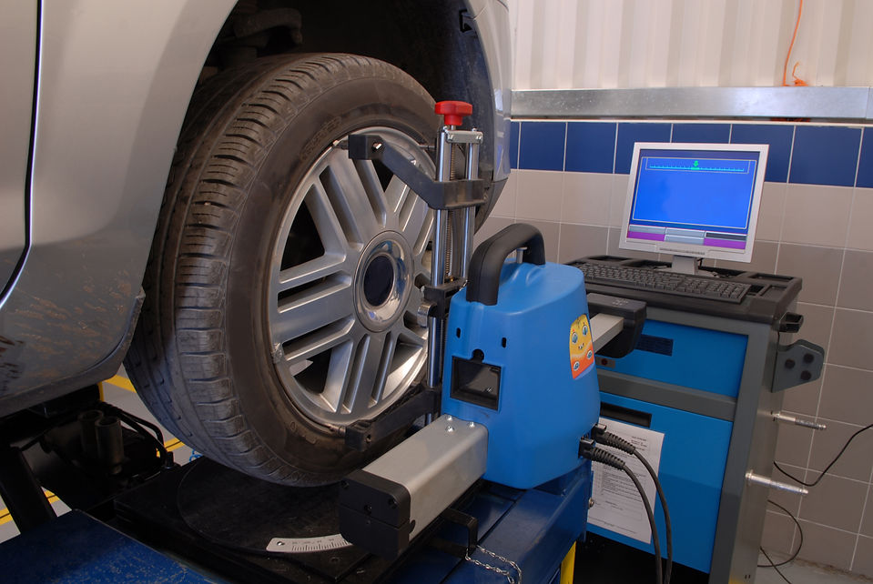 A vehicle tire is secured on a balancing machine in an auto repair shop