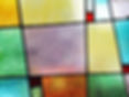 Colorful stained glass with a textured surface, featuring green, purple, yellow, and blue tiles framed in black